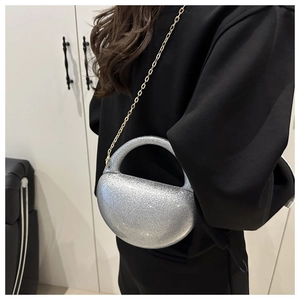 Silver glitter crescent clutch bag with gold chain strap worn as crossbody bag