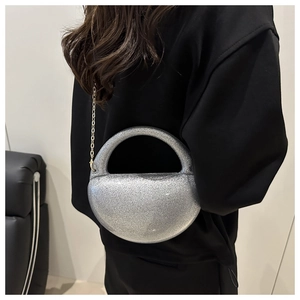 Detail of silver glitter acrylic evening bag with metal chain strap on model