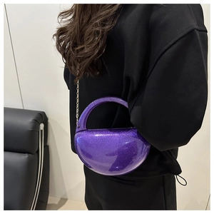Macro view of purple sequined semi-circle evening bag with a delicate metal chain