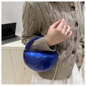 Detail of royal blue acrylic evening bag with gold chain strap and glitter finish