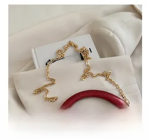 Detailed view of red glitter evening clutch bag with golden metal chain shoulder strap