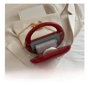 Detail view of red glitter acrylic clutch bag capacity with phone and cosmetics
