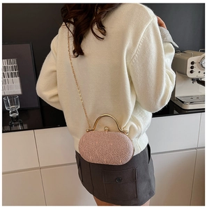 Dettaglio della trama in pizzo rosa e del manico in metallo dorato sulla pochette rigida