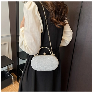 Dettaglio dell'elegante borsa da sera bianca con manico in metallo dorato e rete