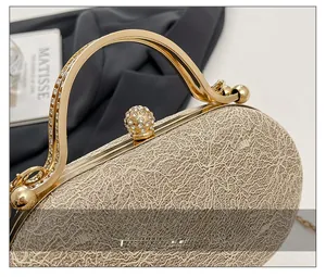 Dettaglio della borsa da sera color champagne con trama a rete e chiusura a sfera