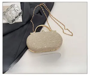 Dettaglio borsa da sera color champagne con trama pizzo metallico e chiusura cristallo