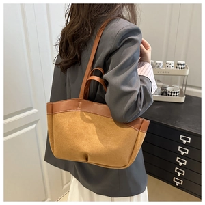 Detail einer großen braunen Wildleder-Tote-Bag mit Glattleder-Nähten an einer Schulter