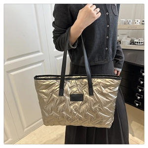 Gros plan détaillé d'un grand sac fourre-tout matelassé doré avec anses en cuir noir