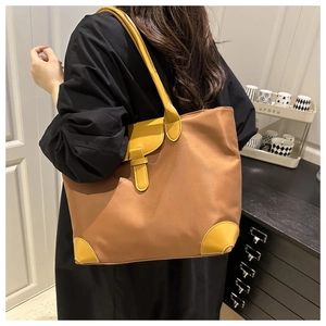 Detail showing the large capacity tote bag worn on shoulder by model in a stylish room