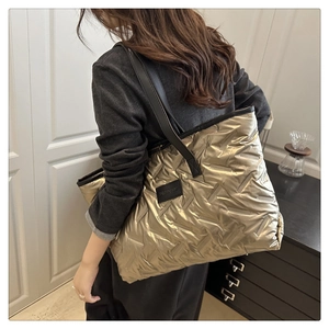 Mannequin portant un grand sac cabas matelassé doré métallisé avec des bandoulières noires