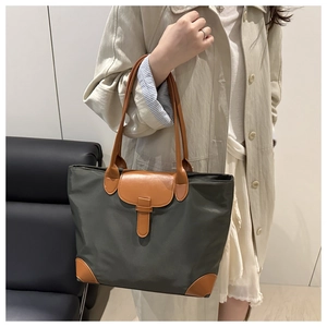 Detailed side view of large nylon tote bag with leather handles on female model
