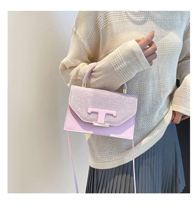Pink sequin crossbody bag styled by model against a minimalist cream background