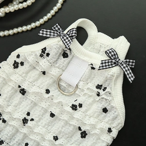 Detail of white lace pet vest with black floral print and metal D-ring for leash attachment