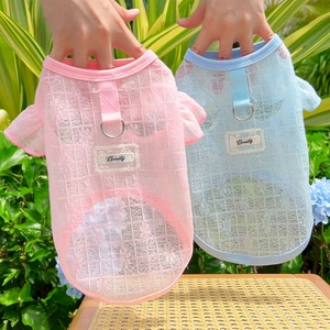 Detail showing two mesh pet vests with lace texture and functional metal D-rings