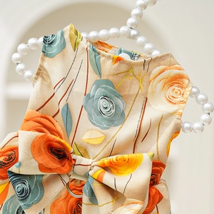 Detailed view of floral pet dress featuring large bow and metal leash D-ring attachment