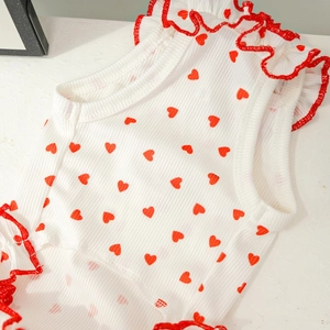 Détail d'une robe pour chien en tricot côtelé avec motifs de cœurs et bords volantés