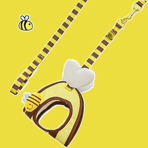 Detail of bee-themed pet harness with 3D plush bee and gold metal buckle on yellow background