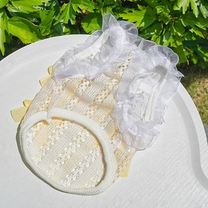 Detailed close-up of yellow lace pet vest with white organza ruffles and bow accents
