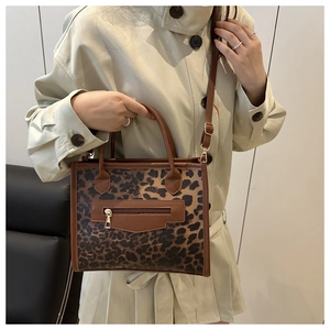 Close-up of leopard print tote bag with gold zipper and adjustable shoulder strap