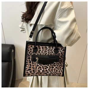 Detail of leopard print tote bag with front zipper pocket and adjustable shoulder strap