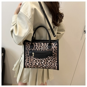 Leopard print tote bag with black front zipper pocket and gold hardware details