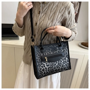 Detail of leopard print tote bag with adjustable shoulder strap and silver zipper closure