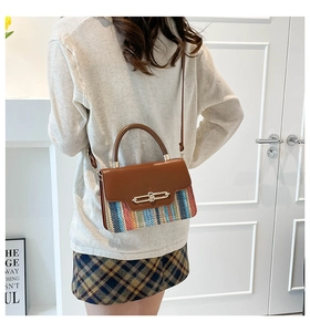 Detail of bohemian woven crossbody bag with brown leather and colorful texture on model