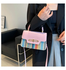 Detail of colorful woven straw and pink leather crossbody bag with gold lock