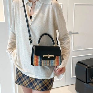 Chic underarm bag with striped woven pattern and black leather flap shown on model