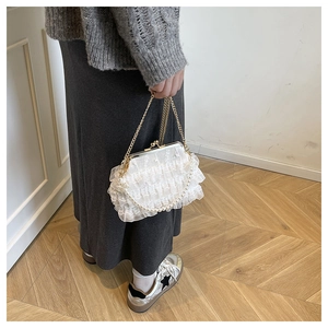 Detailed shot of white lace handbag with pearl handle and golden vintage clasp