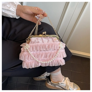 Close-up of pink lace ruffled handbag with vintage gold clasp and pearl chain detail