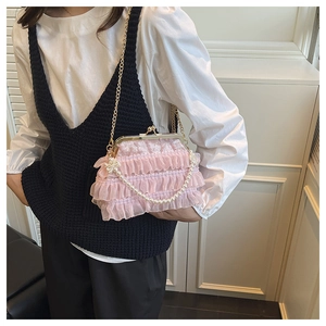 Pink lace ruffle evening bag with pearl handle and metal clasp in a stylish detail view