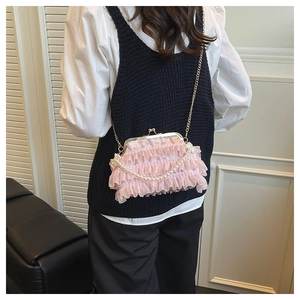 Close-up of pink lace ruffle crossbody bag with pearl accents and gold metal clasp