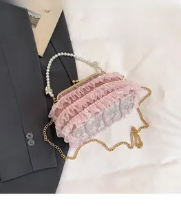 Detailed view of pink lace evening bag with pearl handle and golden chain strap