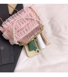 Pink mesh pleated bag with pearl handle and metal clasp showing internal storage space