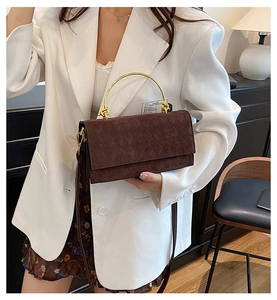 Detailed view of dark brown quilted crossbody bag with stylish gold semi-circular handle