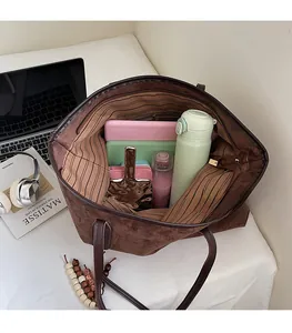 Top view of a large brown suede tote bag showing striped lining and spacious interior