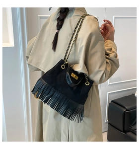 Détail du sac bandoulière matelassé noir avec franges et bandoulière en chaîne dorée