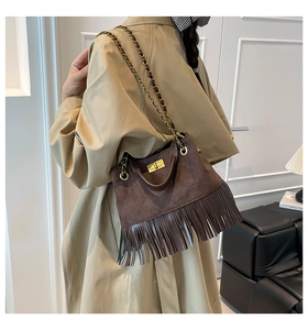 Détail du sac en daim matelassé marron foncé avec franges et bandoulière dorée