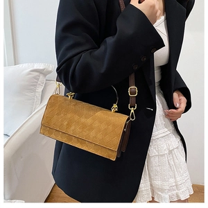 Detail view of brown quilted suede texture and elegant gold semi-circle handle on handbag