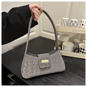Détail du sac sous le bras à imprimé léopard gris avec boucle dorée et texture daim