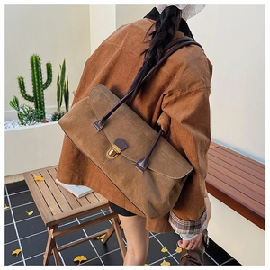 Brown frosted leather bowling bag worn over the shoulder with vintage metal buckle detail