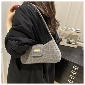 Détail du sac porté épaule léopard gris en velours avec boucle dorée sur mannequin