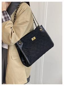 Détail du sac fourre-tout noir matelassé en daim avec chaîne dorée et fermoir pivotant