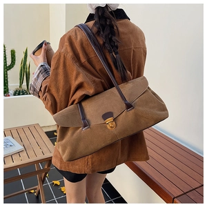Detail of vintage brown suede tote bag with elegant golden metal clasp closure