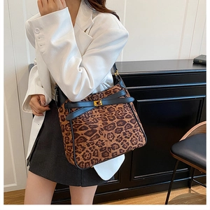 Detail of leopard print bucket bag with gold clasp and leather cross straps