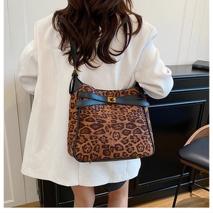 Leopard print tote bag detail showing golden twist lock and suede texture on shoulder bag