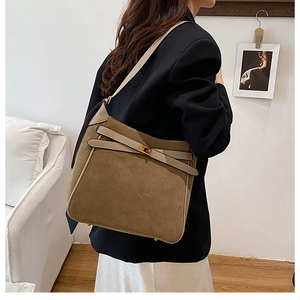 Side view of large brown suede tote bag with leather trim and gold buckle details