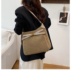 Detail view of olive green suede hobo bag with gold twist lock and beige leather trim
