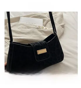 Détail du sac bandoulière léopard noir en daim avec boucle métallique dorée